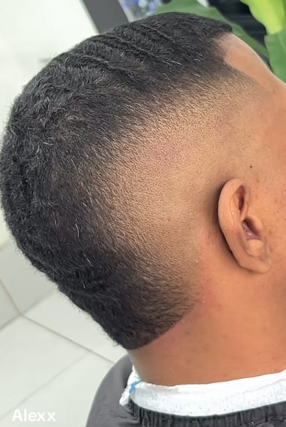 Corte visto desde atrás, con el pelo corto arriba y un degradado en la nuca.