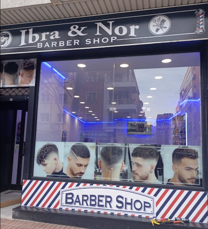 Fachada de Ibra & Nor Barber Shop con el rótulo Ibra & Nor y Barber Shop sobre el escaparate.